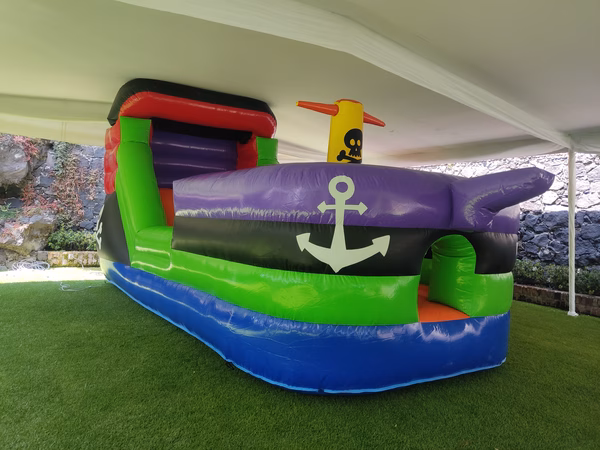 Renta brincolin Barco Pirata CDMX - Inflable grande con ancla y tobogán instalado en jardín bajo carpa